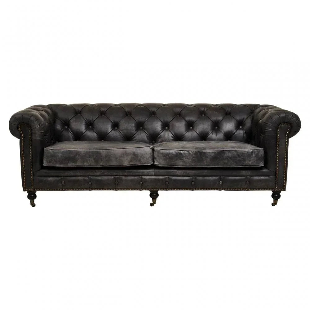 Black leather Chesterfield sofa with tufted back and brass nailhead trim on wooden legs