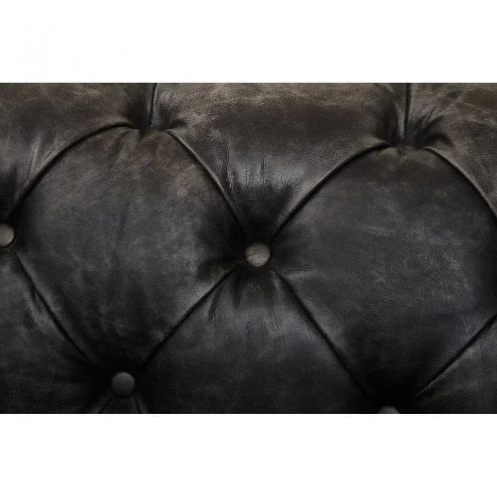 Closeup of black leather sofa backrest with deep button tufting