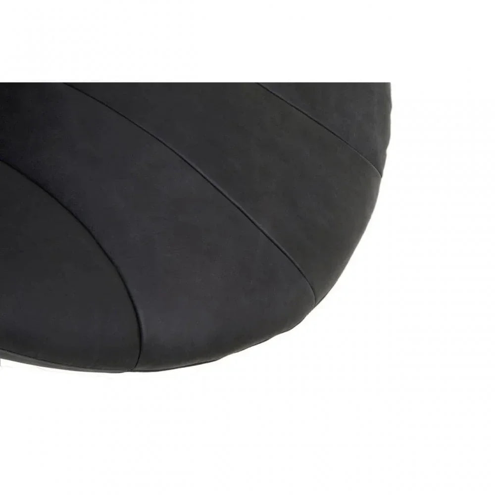 Closeup of black faux leather upholstery on rounded seat cushion
