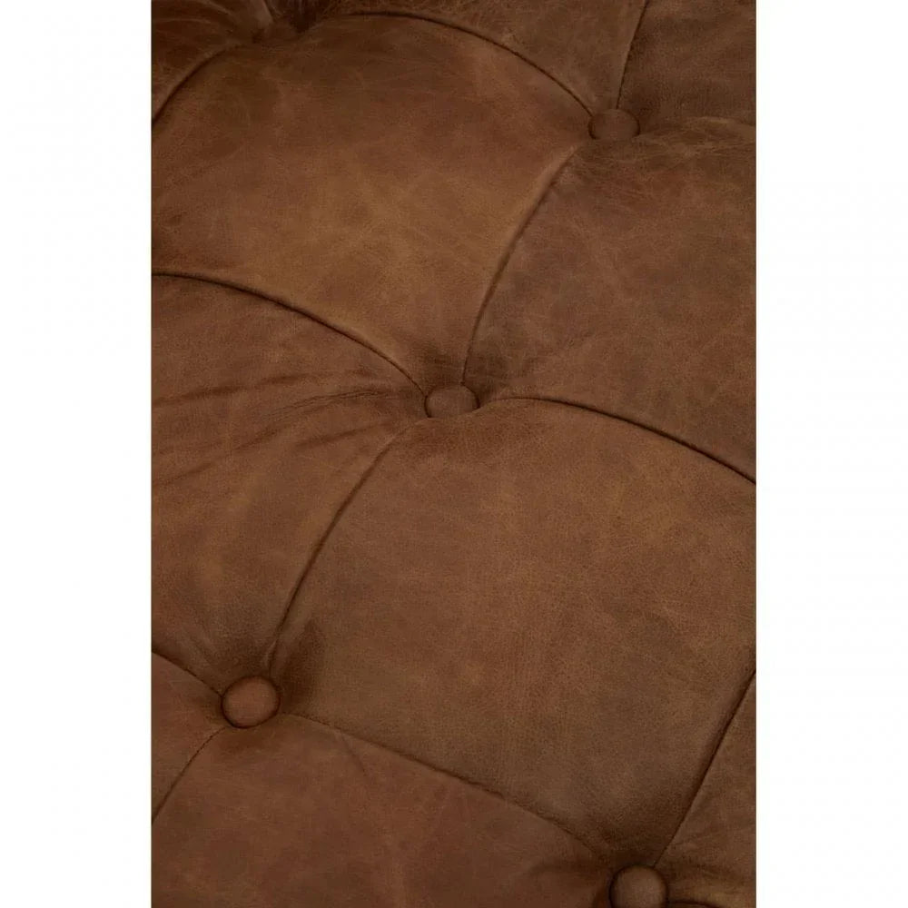 Close up of brown leather sofa upholstery with deep button tufting detail