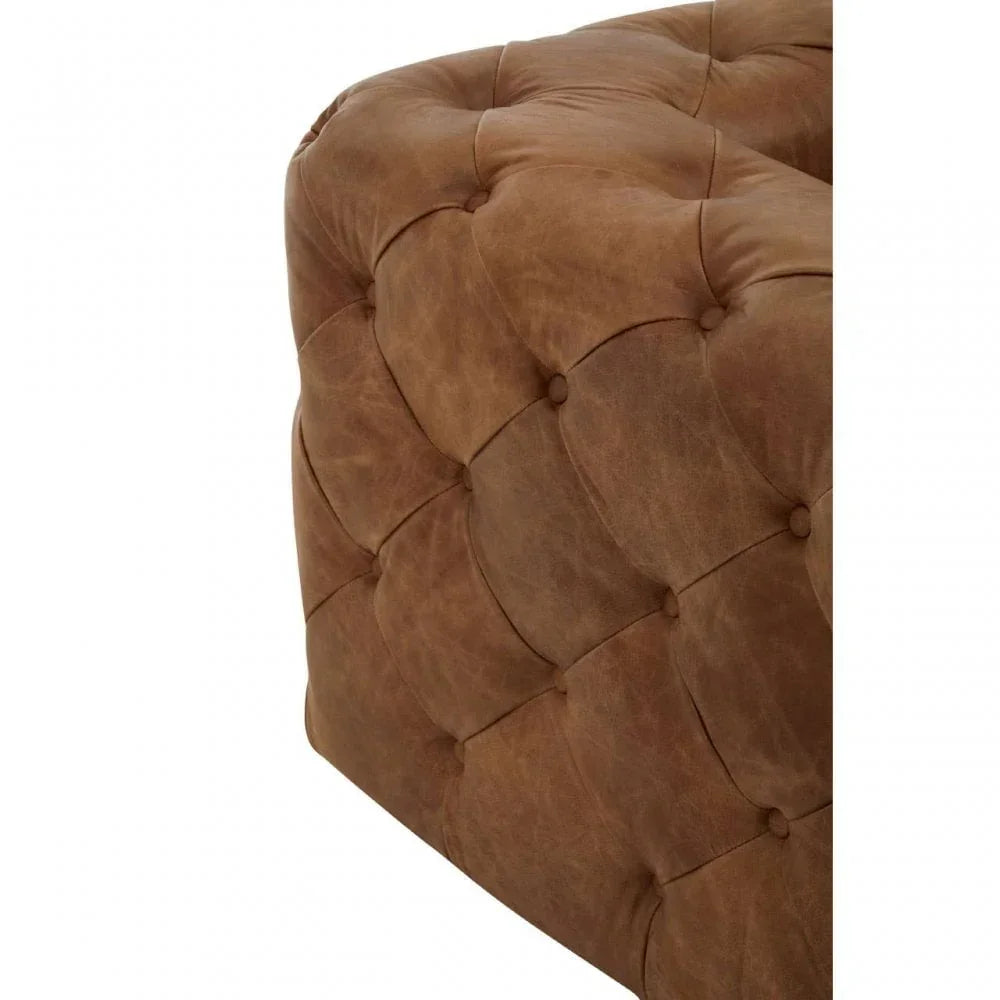 Brown leather ottoman with deep button tufting and soft upholstery close-up