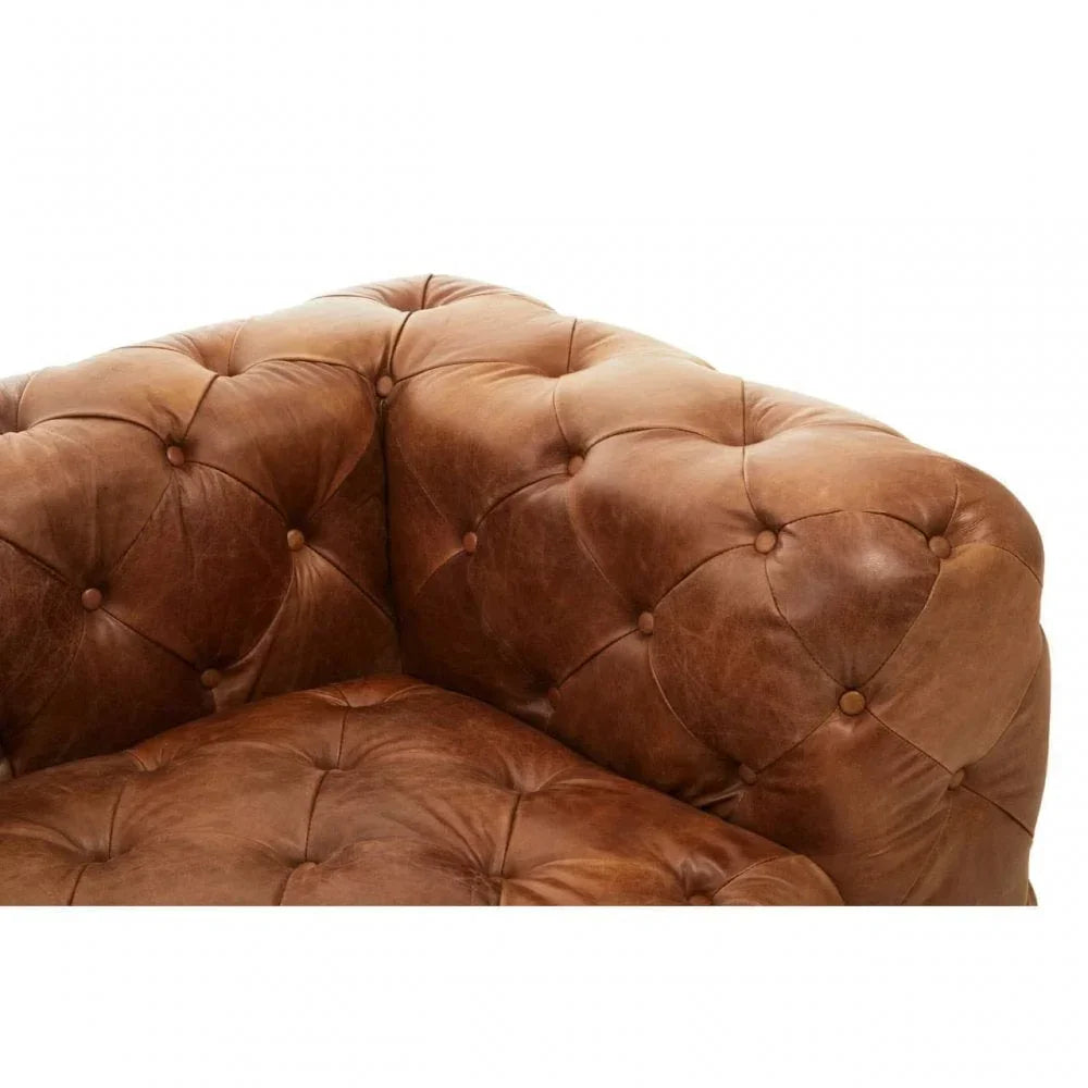 Closeup of brown leather sofa with deep button tufting and plush cushions