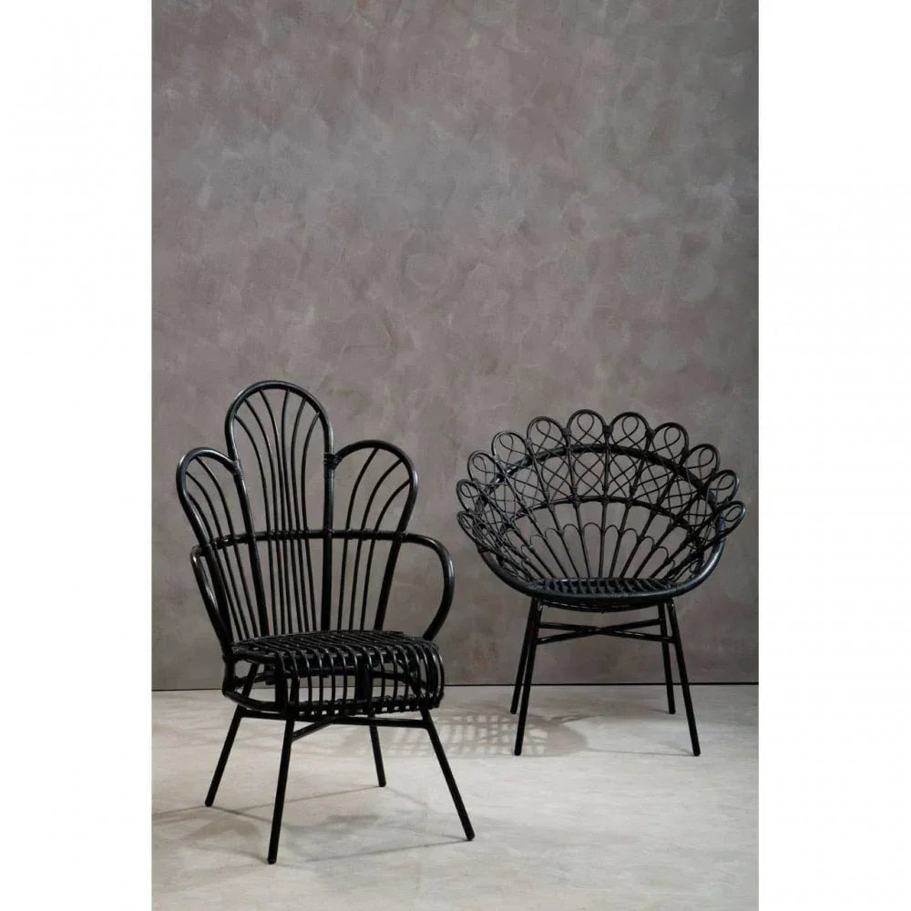 Black rattan accent chairs with decorative open backrests on a neutral indoor floor