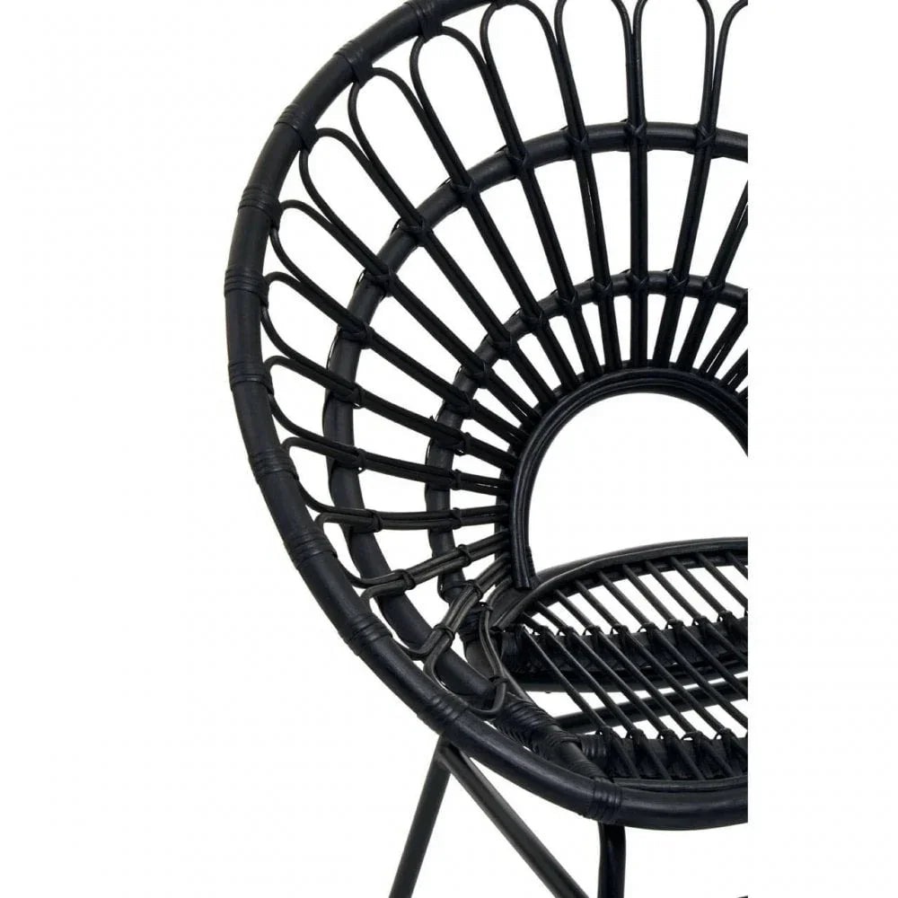 Black rattan accent chair with circular open-weave backrest, close-up view