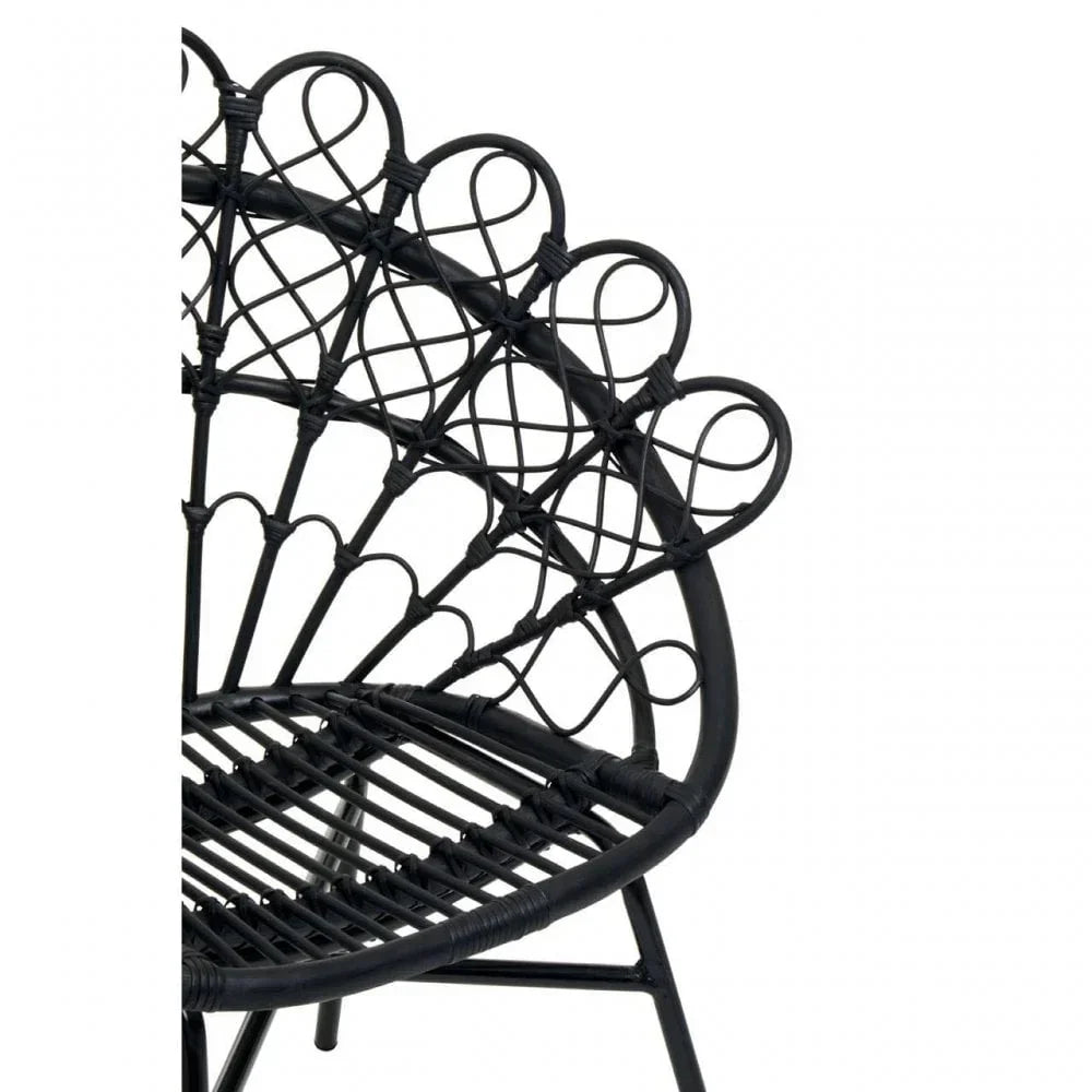 Black rattan accent chair with decorative looped backrest detail, partial side view