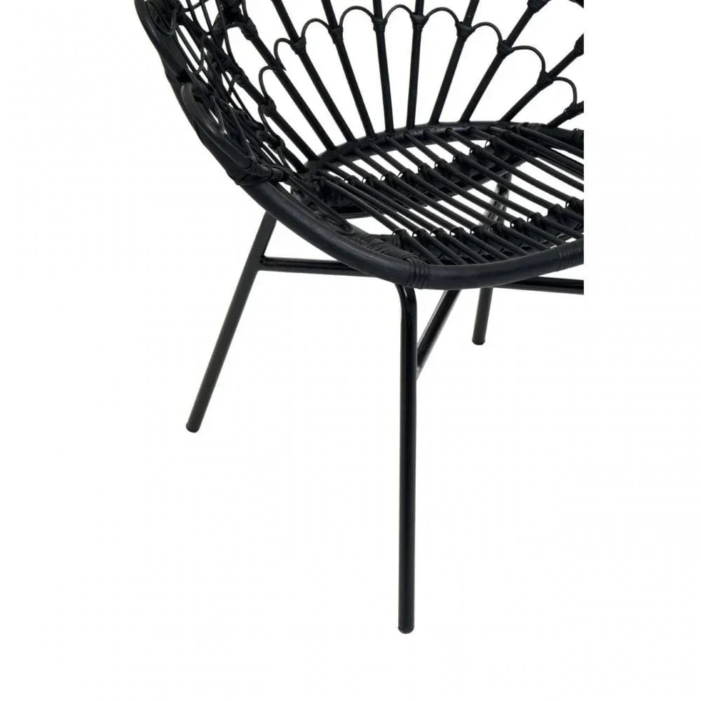 Black rattan accent chair with metal legs and open weave seat, close-up view