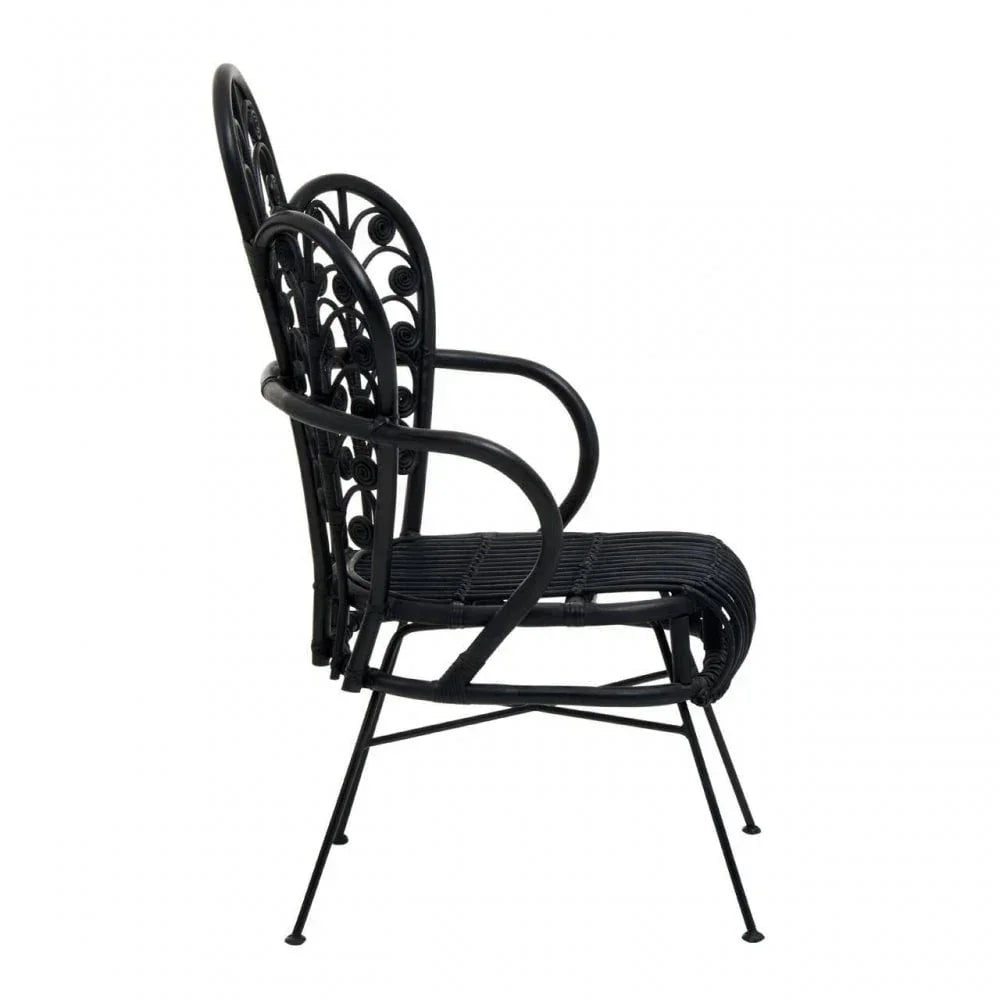 Black rattan dining chair with decorative scroll back and armrests, side profile view