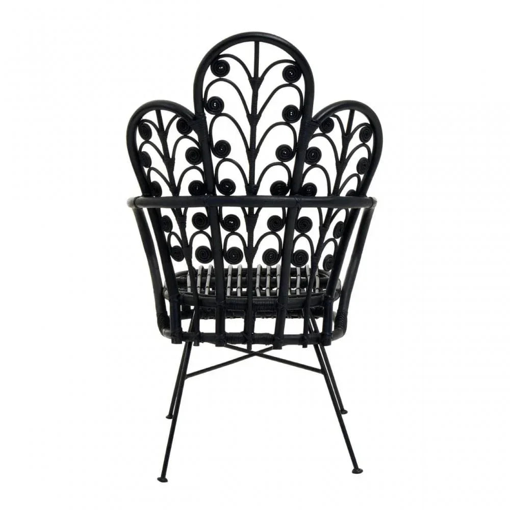 Black rattan accent chair with decorative curved back and metal legs, rear view