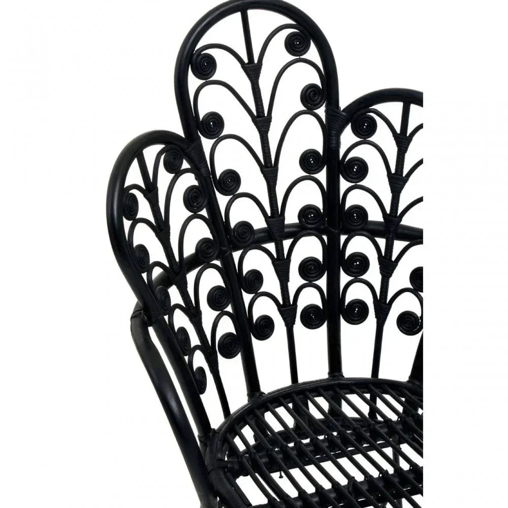 Black rattan chair with intricate scrollwork detail and curved backrest
