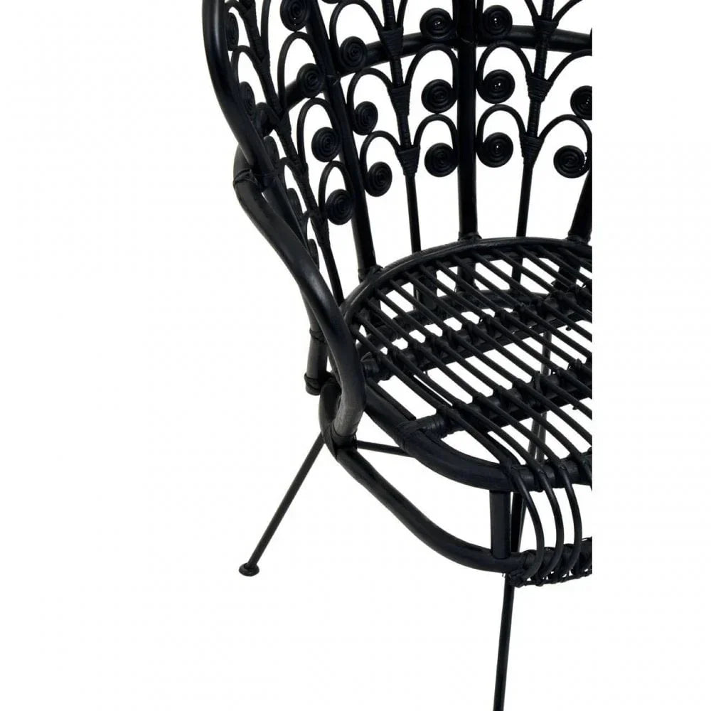 Black rattan chair with decorative swirl backrest and metal legs, close-up angle