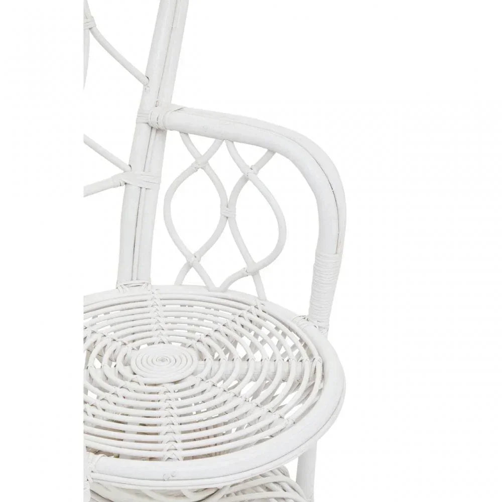 White rattan chair with round seat and decorative woven backrest, close-up view