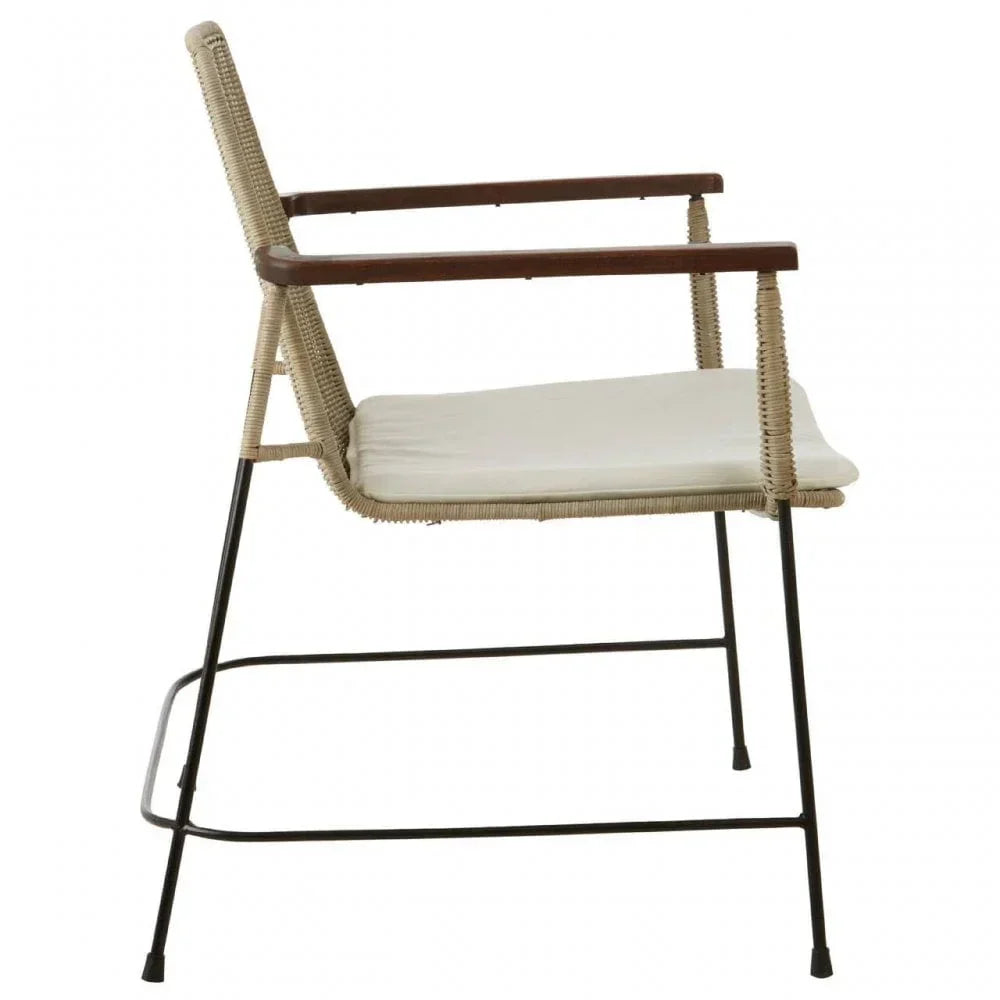 Modern rattan dining chair with black metal legs, wooden armrests, and cream seat cushion