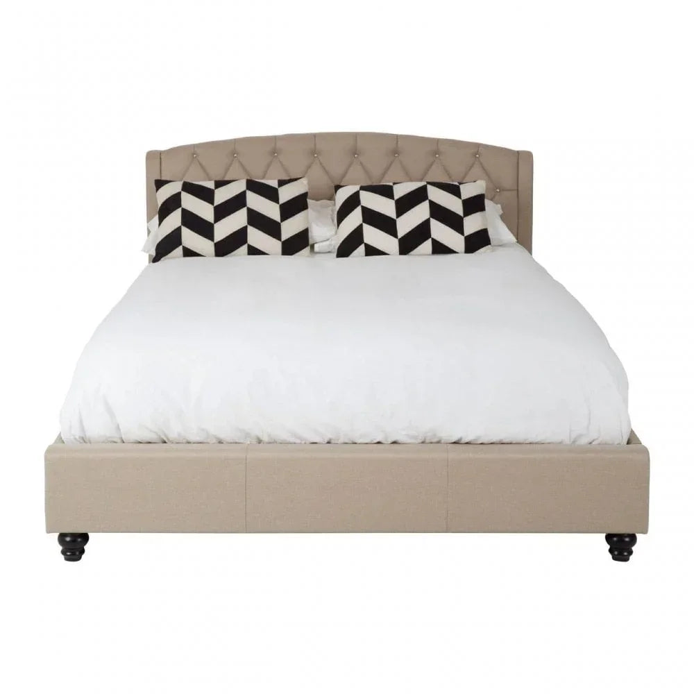 Beige upholstered bed frame with tufted headboard and monochrome geometric pillows