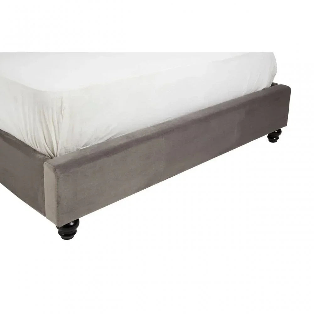Grey upholstered bed frame with white mattress and black turned wooden legs
