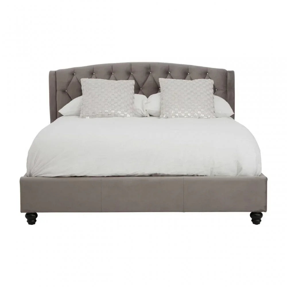 Grey upholstered bed frame with button-tufted headboard, white bedding and decorative pillows