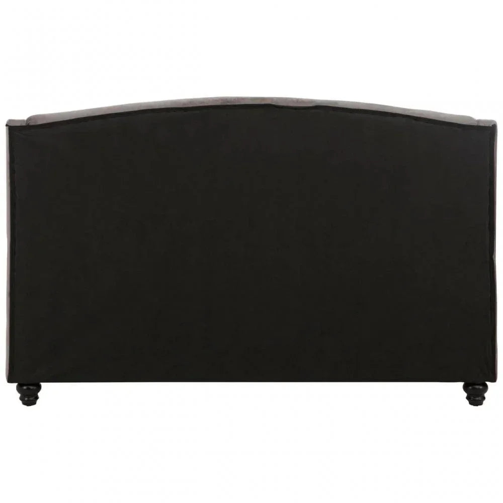 Rear view of black upholstered sofa with curved backrest and turned wooden legs