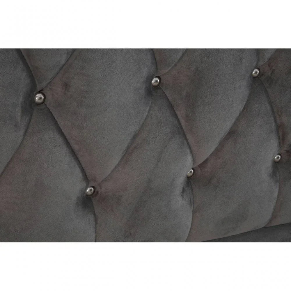 Grey velvet upholstered bed headboard with diamond button tufting and metal studs detail