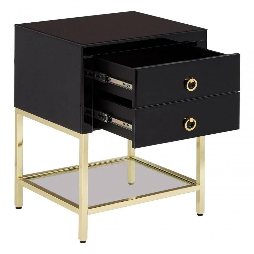 Black bedside table with gold metal legs, two drawers, and glass lower shelf