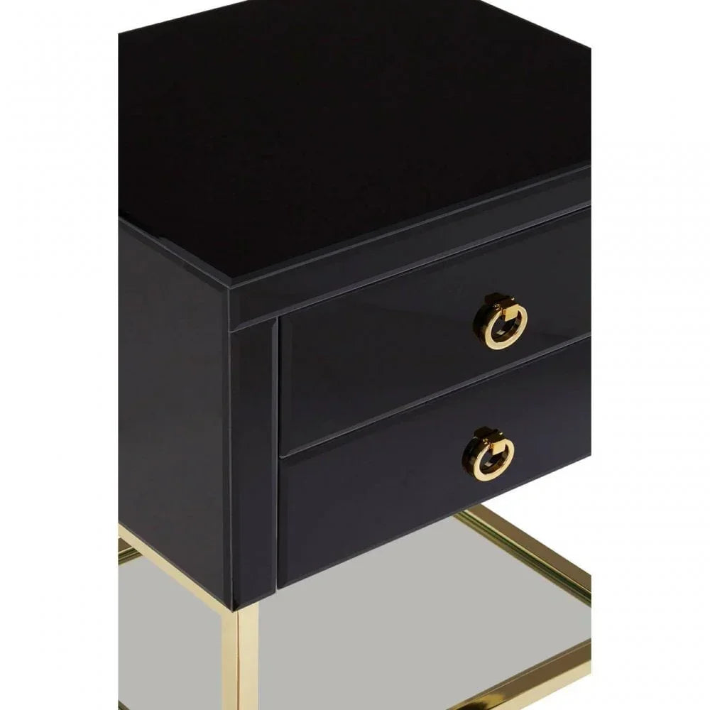 Black bedside table with gold metal legs and two drawers featuring gold ring handles