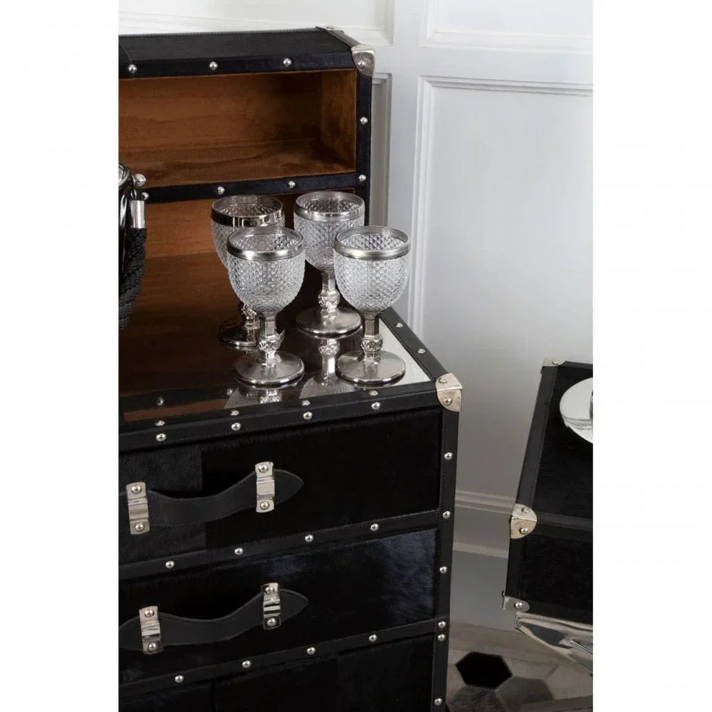 Black leather trunk cabinet with silver stud accents and crystal wine glasses on top