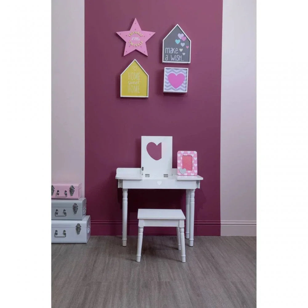 White children’s dressing table set with stool against pink accent wall, decorative wall art