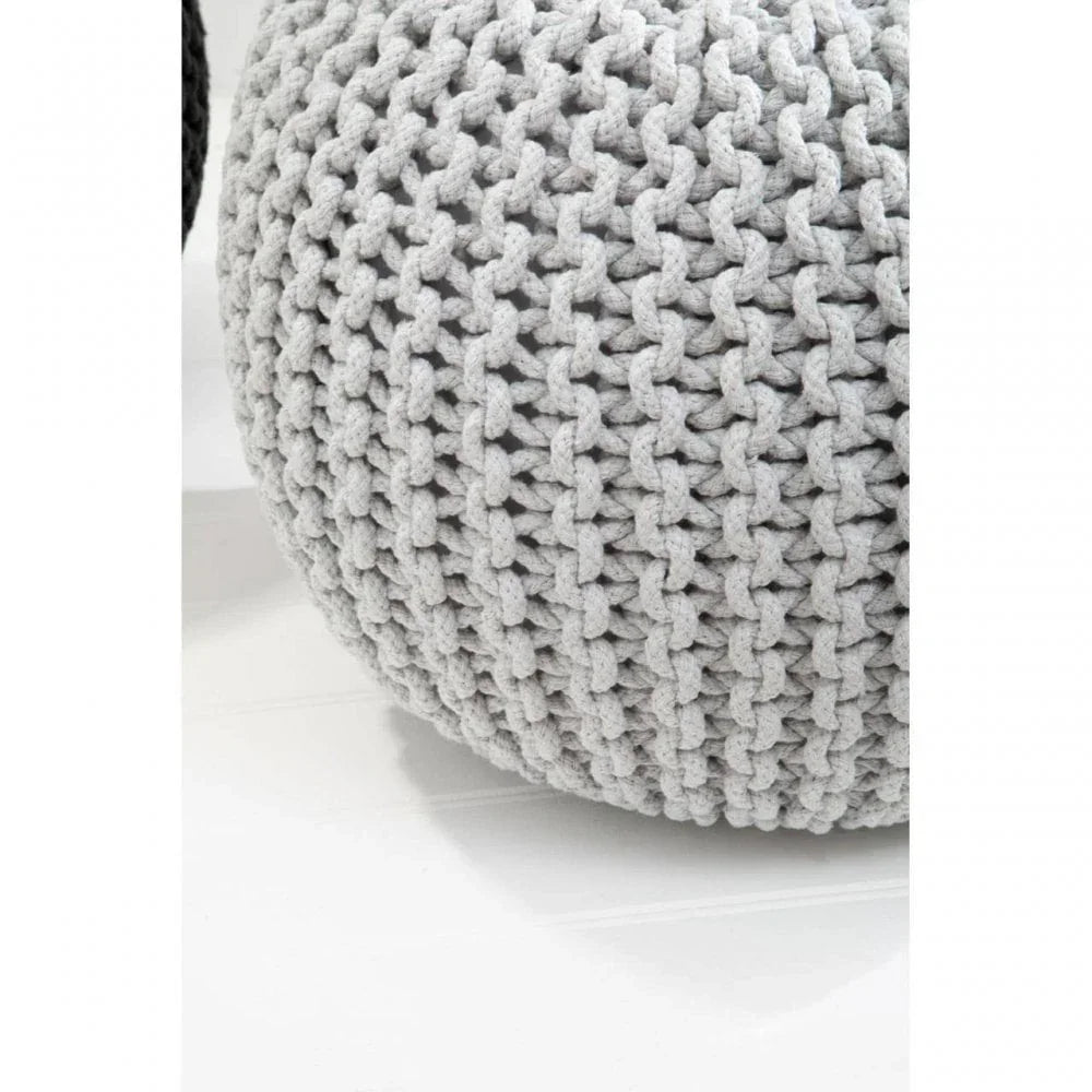 Light grey knitted pouffe footstool with chunky textured weave on white floor