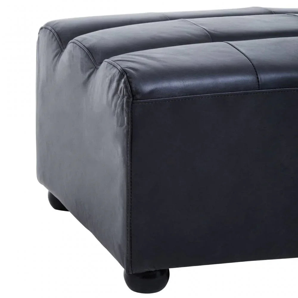 Black leather ottoman with stitched detail and low round feet, close side view