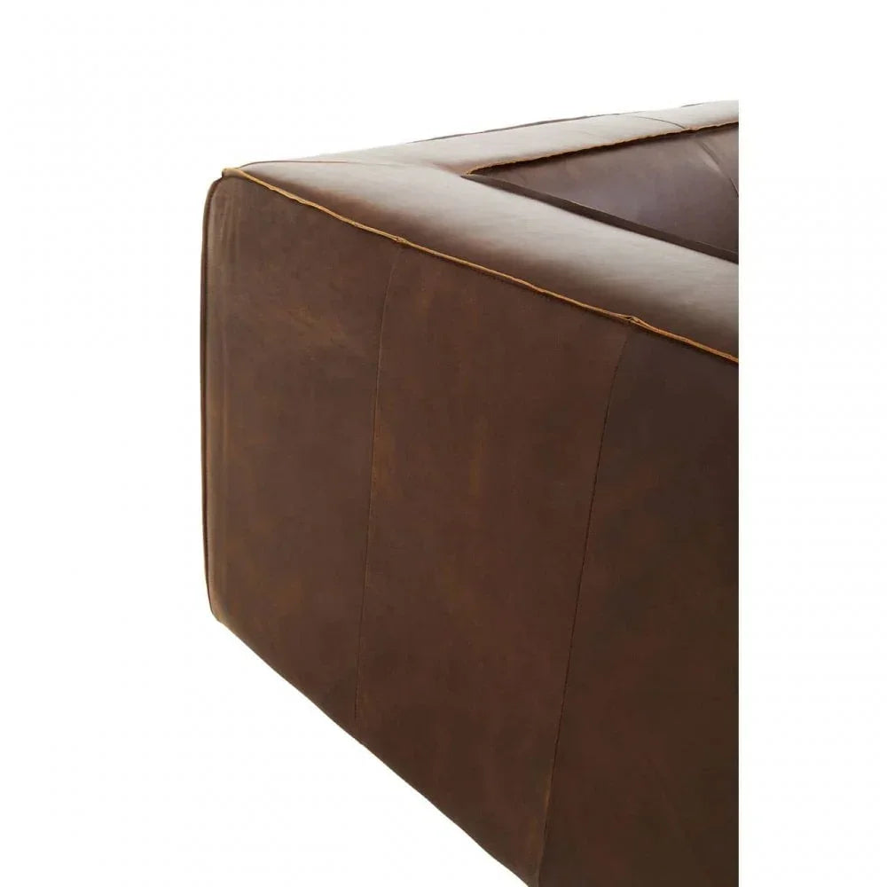 Corner detail of brown leather sofa with visible stitching