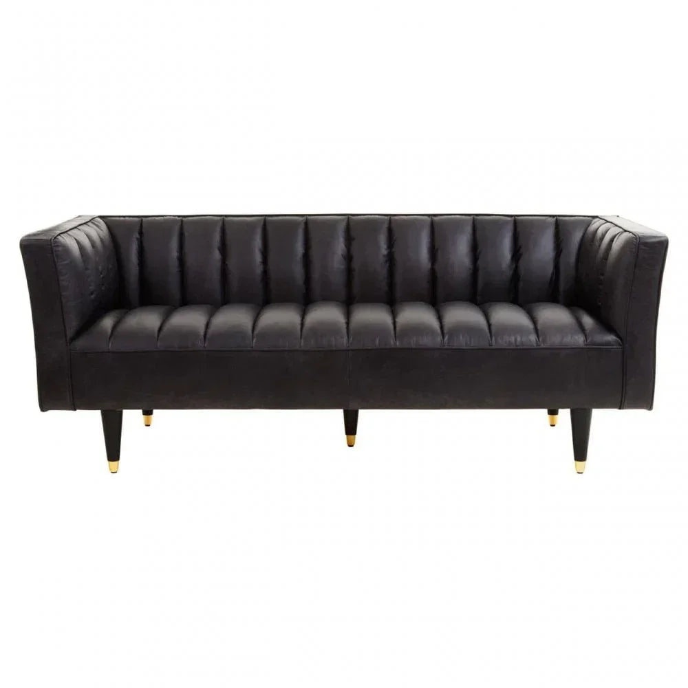 Black leather sofa with vertical tufted backrest and gold-tipped legs, front view