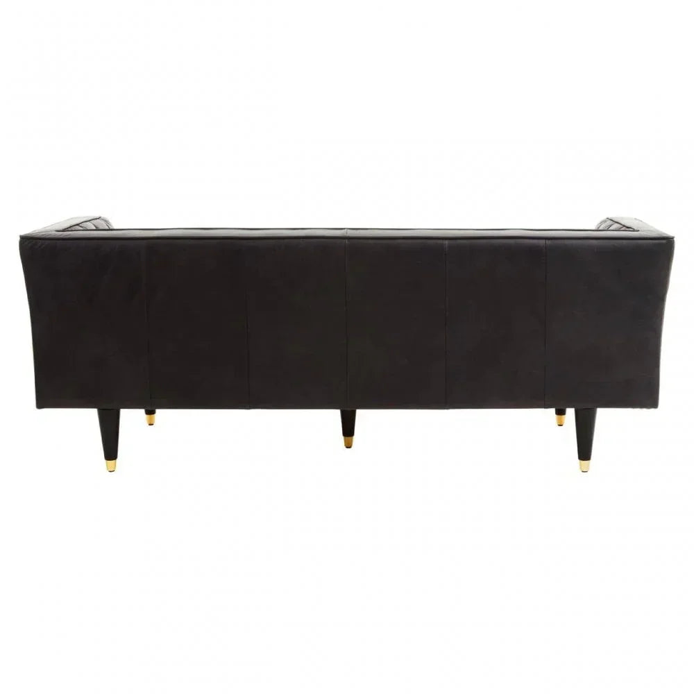 Back view of black leather sofa with tapered legs and gold accents