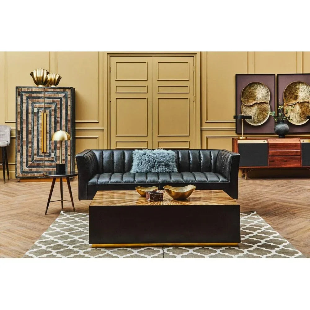 Black leather sofa with blue cushion and wooden coffee table in modern living room setting