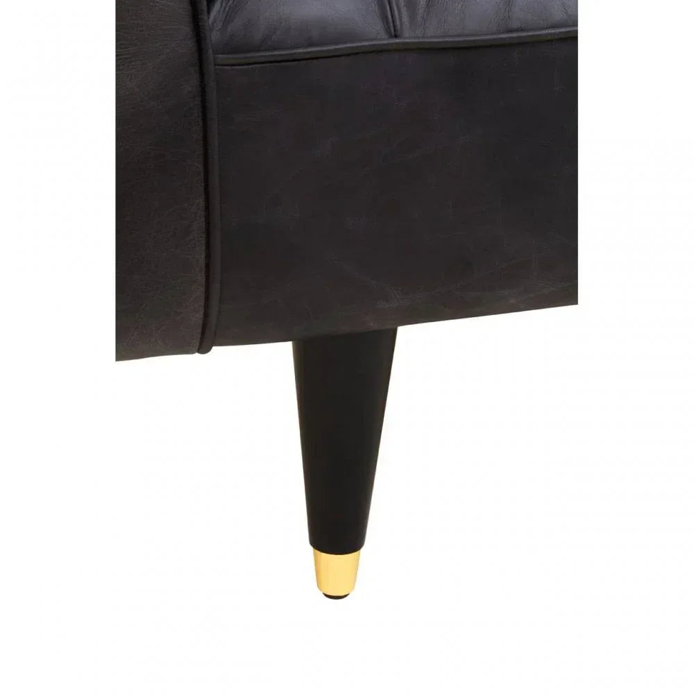 Black sofa corner with tapered black leg and gold metal foot detail