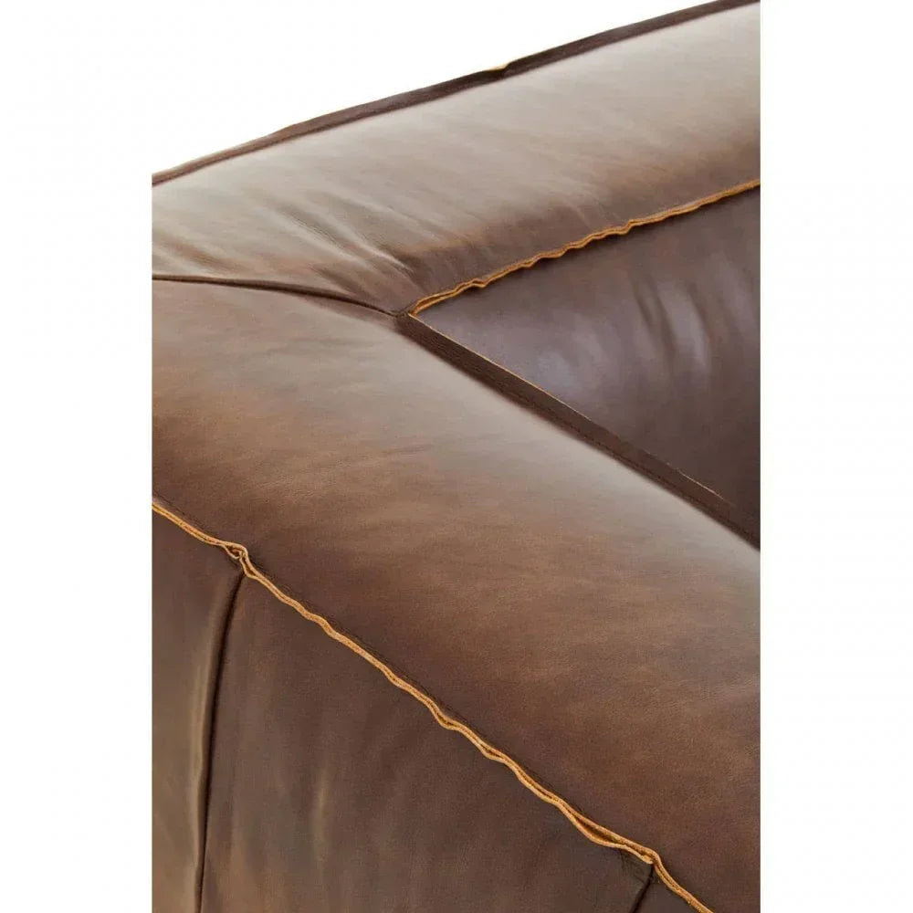 Close view of brown leather sofa arm with visible stitching detail