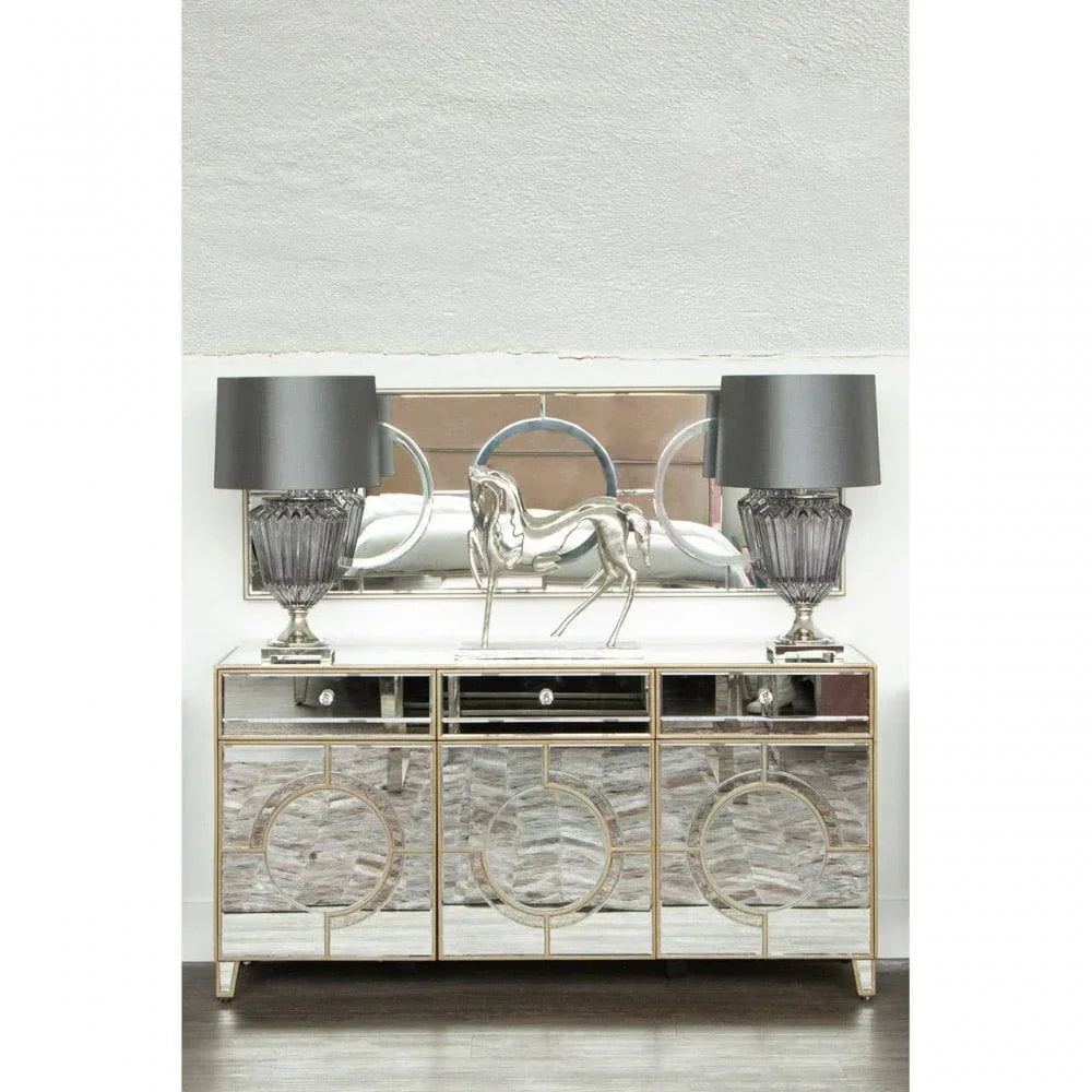 Mirrored sideboard with circular detailing, two grey lamps and silver horse ornament