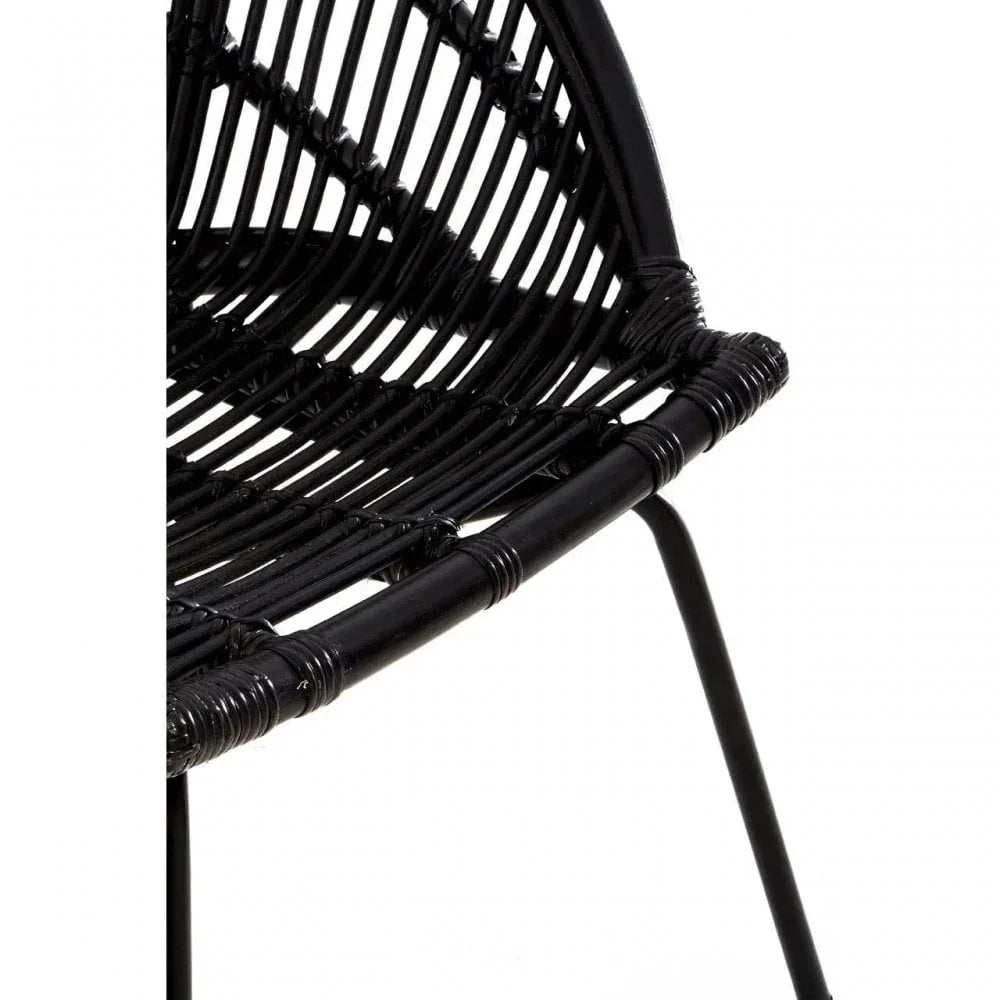 Close up of black rattan dining chair seat and curved backrest with metal legs