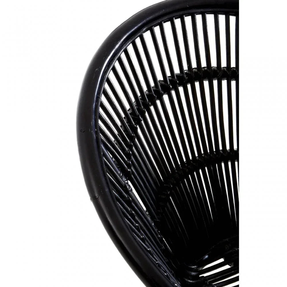 Close-up of black rattan dining chair with curved backrest and vertical slats