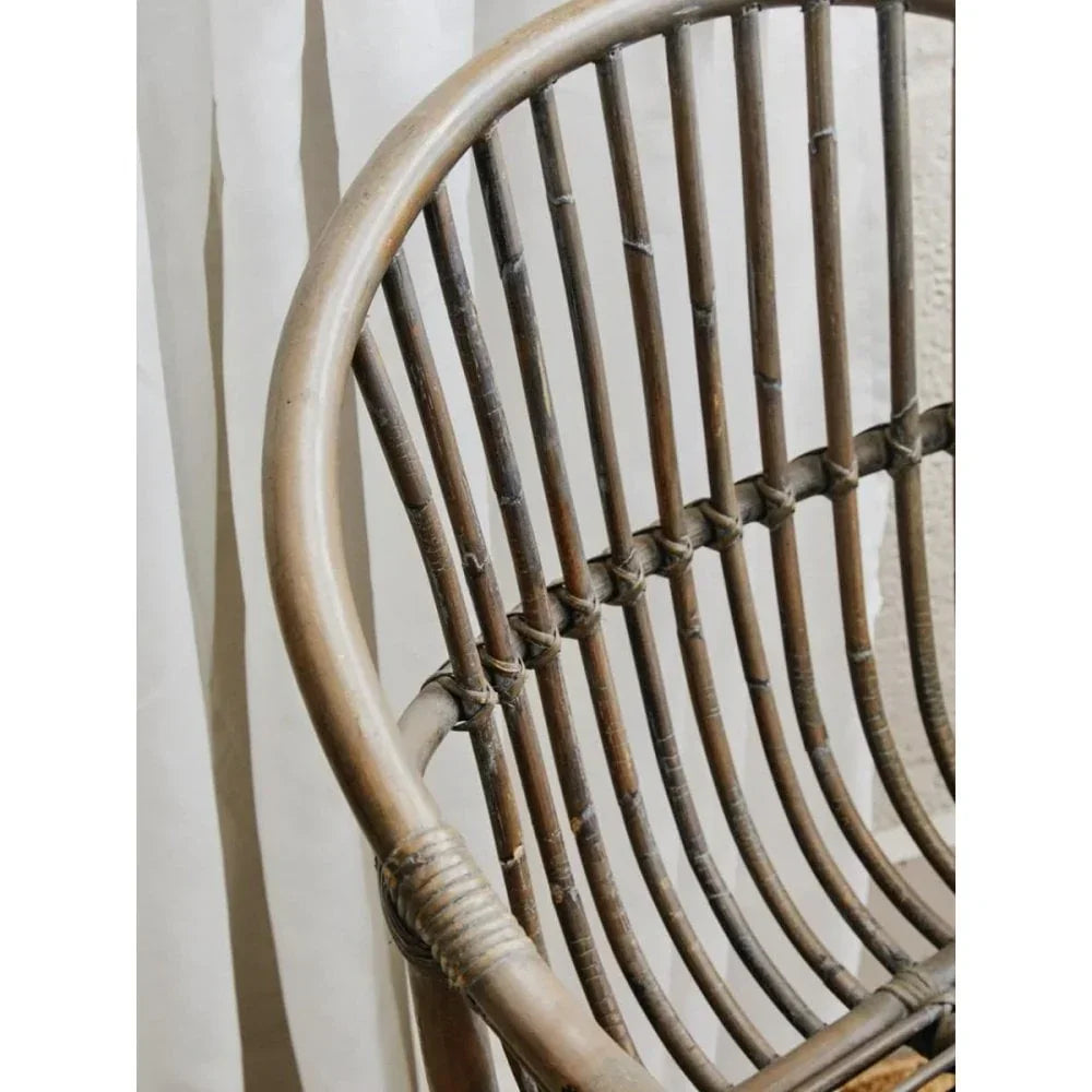 Curved rattan chair backrest with vertical slats and natural wood finish