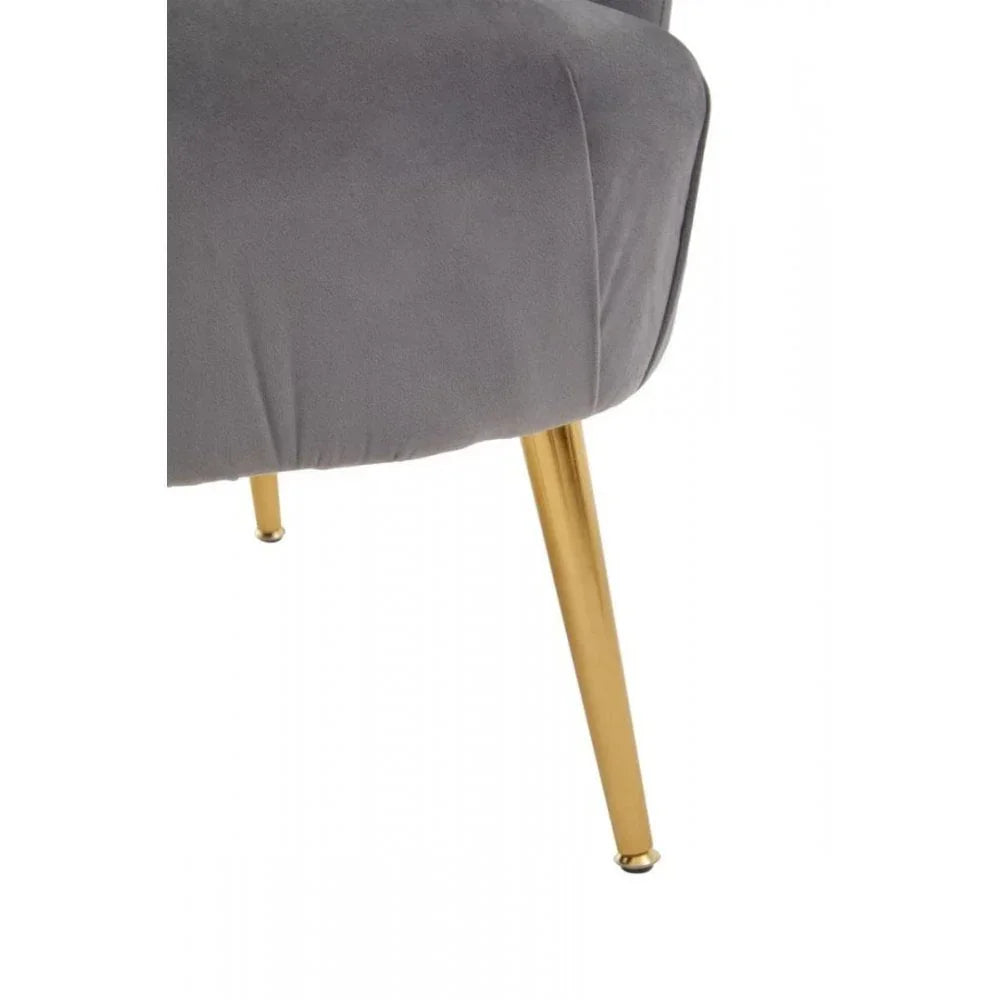 Grey velvet chair with gold metal legs close up