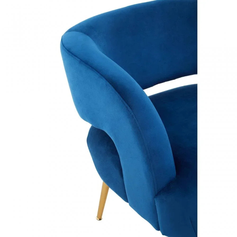 Blue velvet accent chair with curved backrest and gold metal leg detail