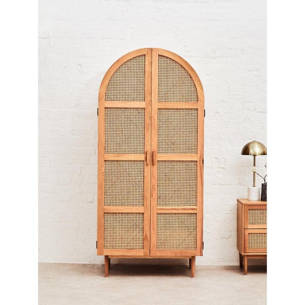 Natural wood storage cabinet with arched rattan doors in modern living room setting