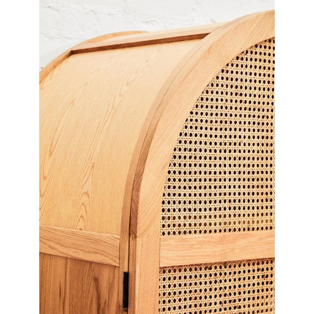 Curved oak cabinet with natural rattan panel and visible wood grain detail
