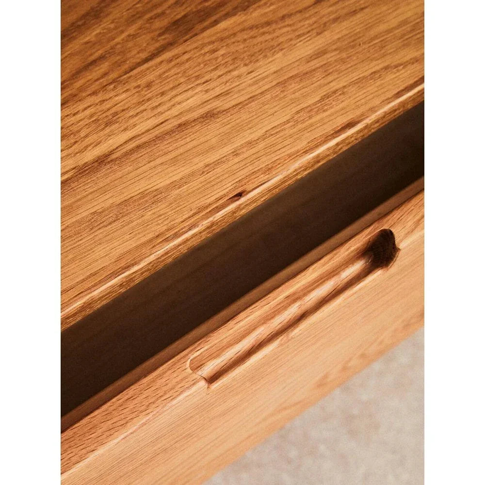 Close-up of oak wood drawer with integrated handle and natural grain texture