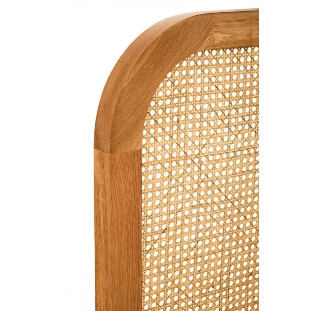 Closeup of natural oak wood and cane bed headboard with rounded corner detail