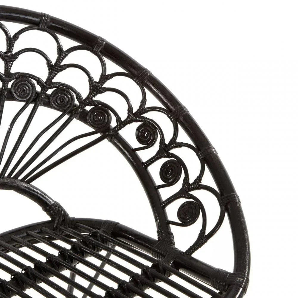 Black rattan chair backrest with decorative swirl pattern and slatted seat detail