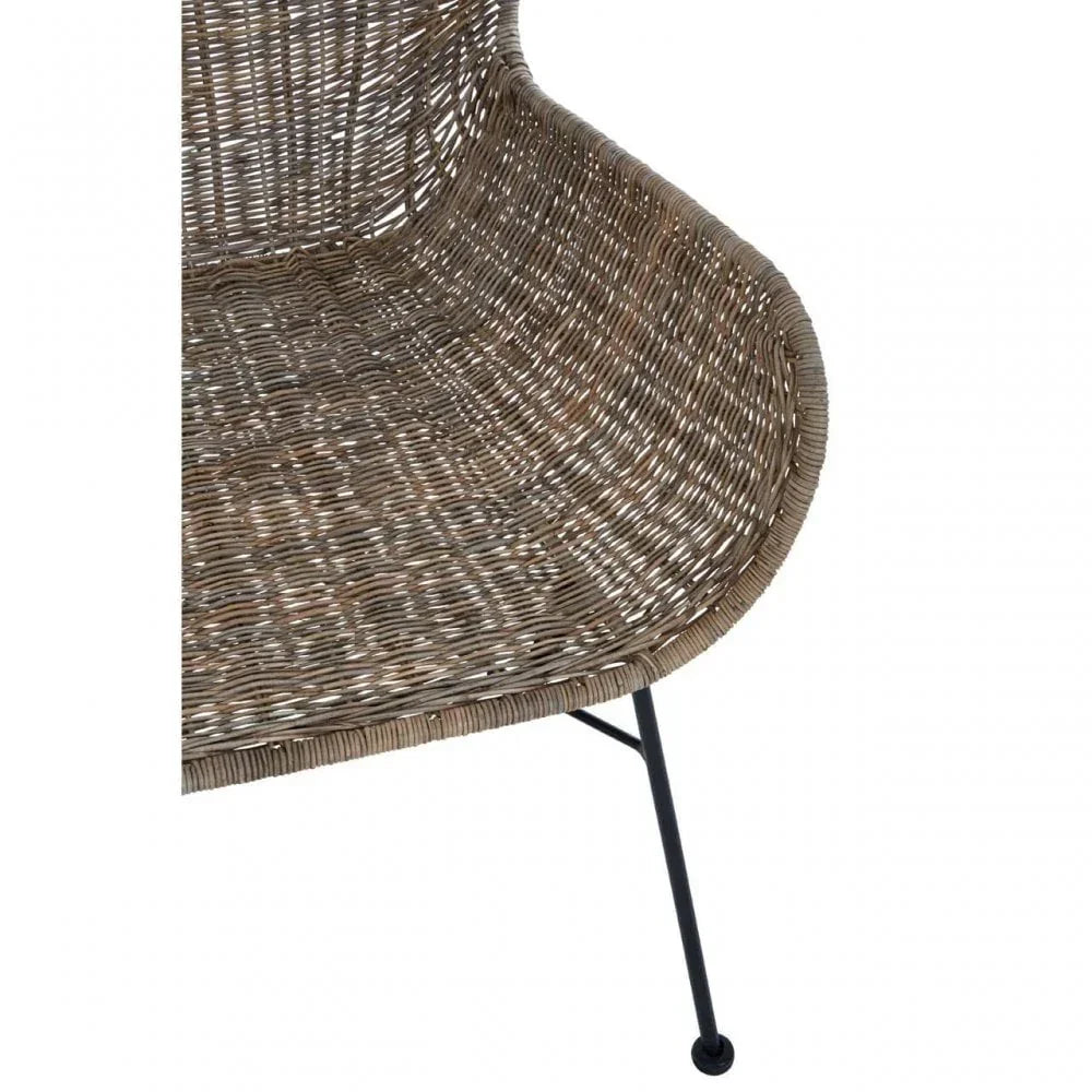 Closeup of rattan chair seat with curved design and black metal leg