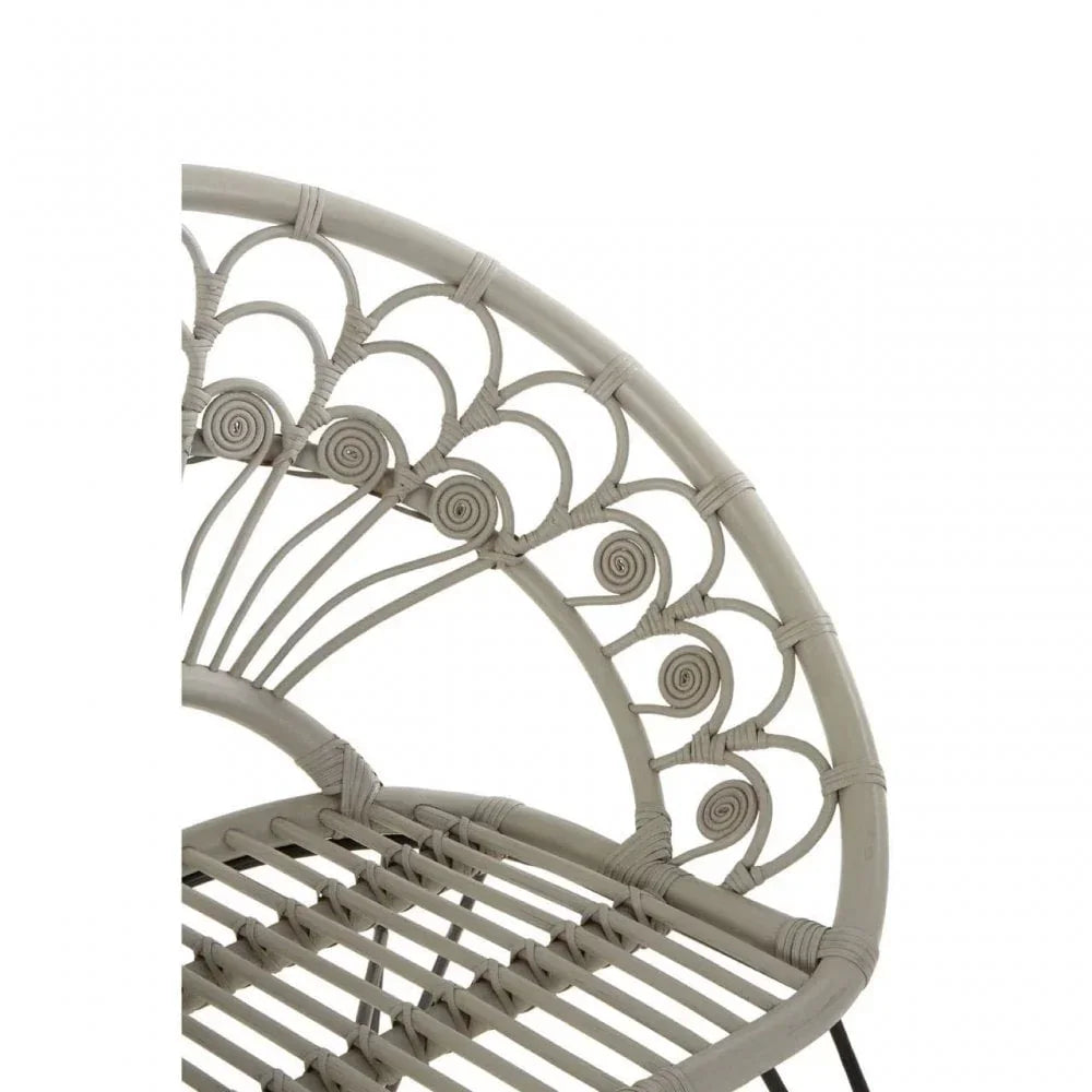 Close up of curved rattan chair backrest with intricate woven swirl detail