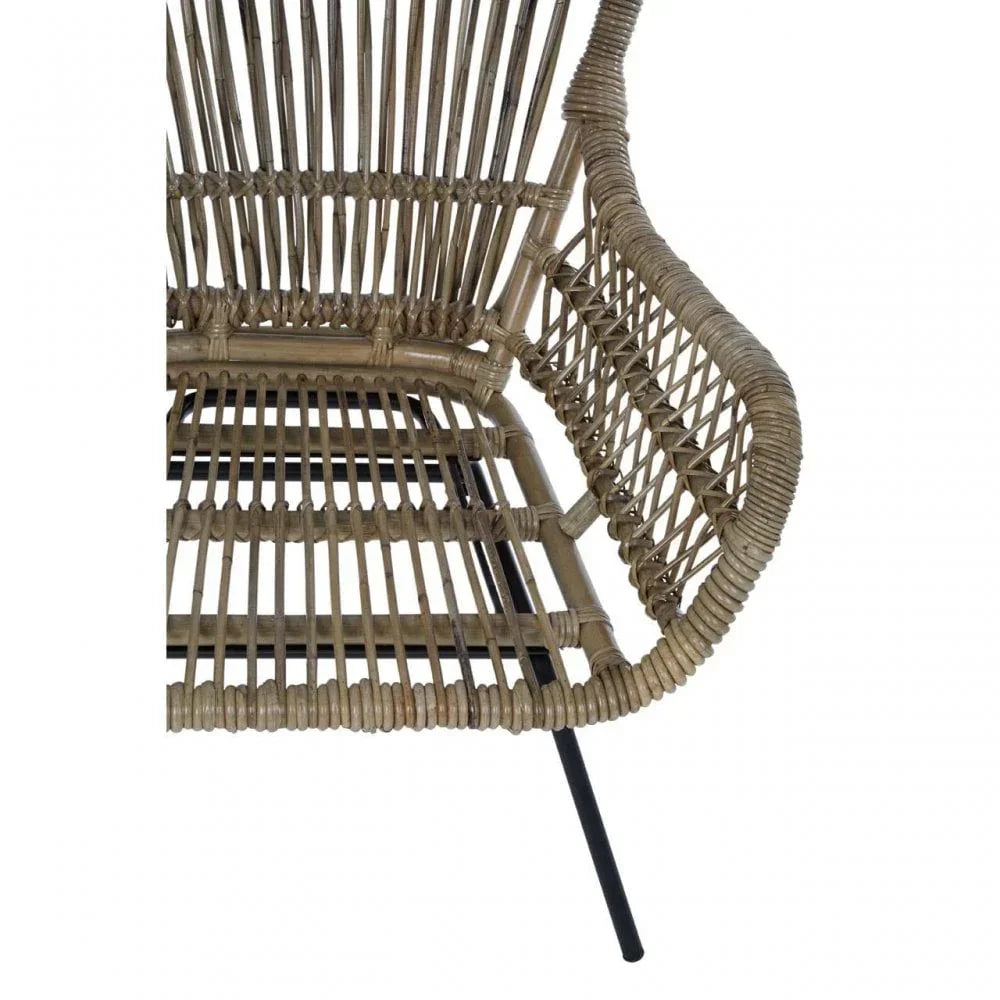 Close-up of rattan dining chair armrest and seat with black metal leg