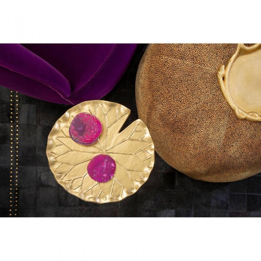 Gold leaf decorative tray with two pink accents beside velvet and textured cushions