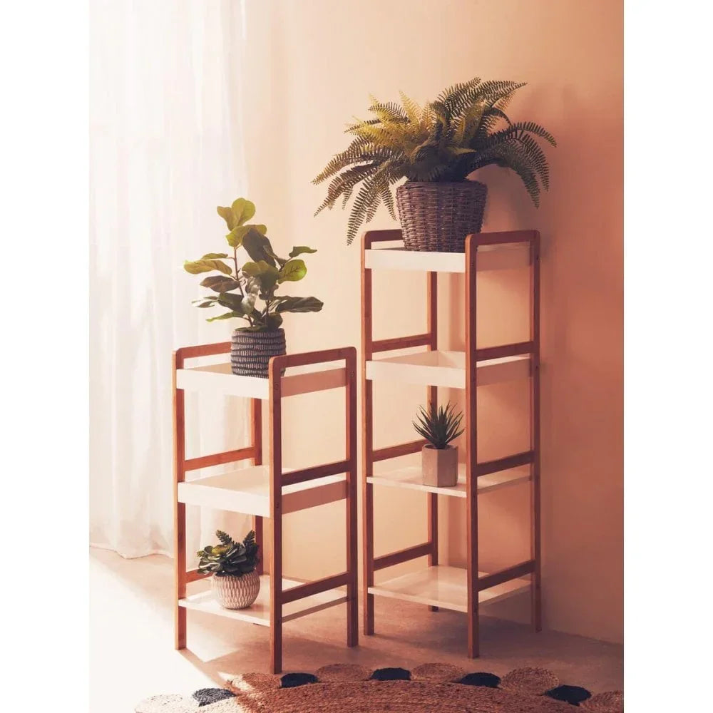 Wooden shelving units with white shelves holding potted plants in a sunlit living room corner