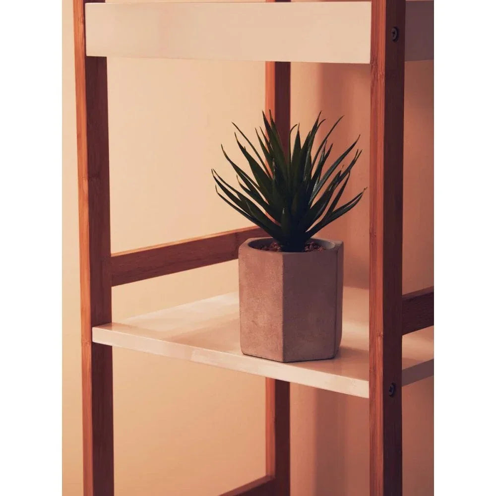 Green artificial plant in concrete pot on wooden shelf unit